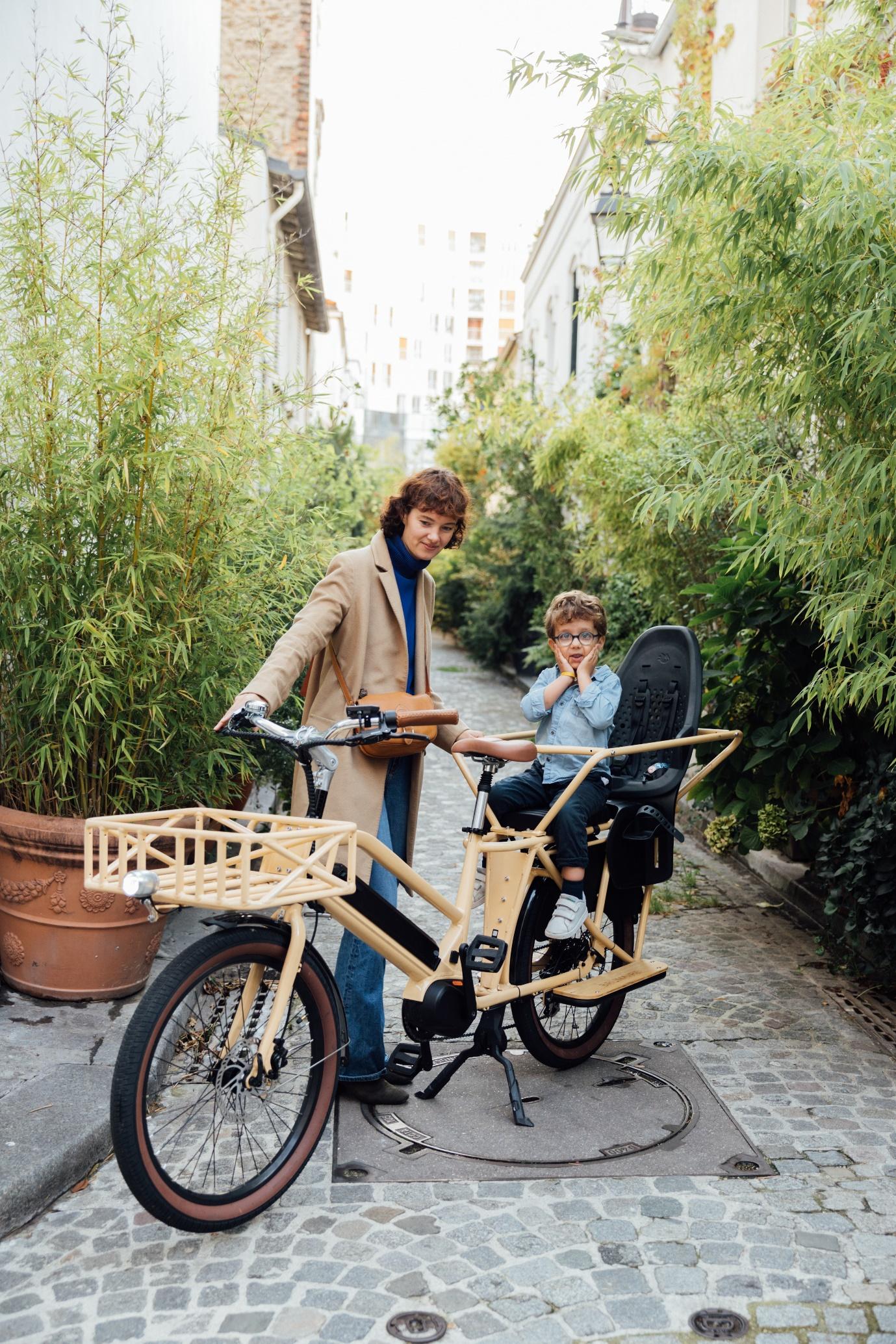 Une femme et son enfant sur un vélo cargo